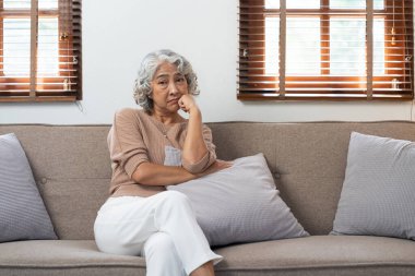 Huzurevinde yaşlı bir Asyalı kadın üzgün, üzgün, mutsuz, yaşlı insanların ruh sağlığı konusunda düşünceli.