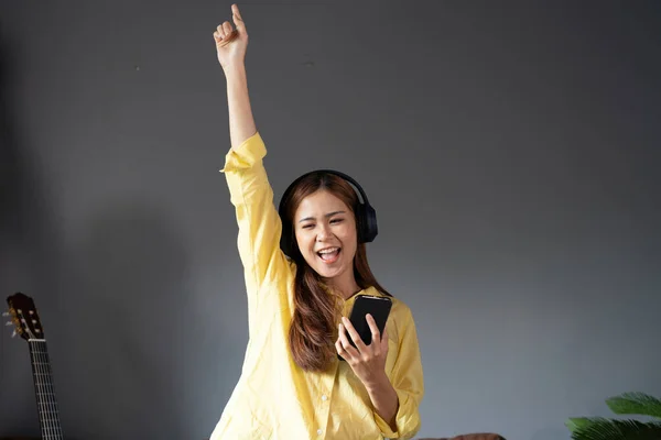 Szczęśliwa Kobieta Słucha Muzyki Poprzez Bezprzewodowe Słuchawki Stojące Kanapie Domu — Zdjęcie stockowe
