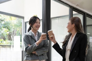 Çeşitli çalışanlar kahve molası sırasında sohbet ediyorlar, modern ofiste yürüyorlar, Asyalı iş kadını gözlük takıyor fikirleri paylaşıyor, projeyi meslektaşlarıyla tartışıyor, hoş sohbetler ediyorlar..