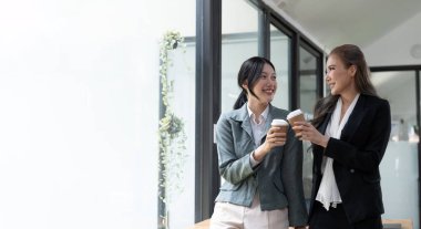 Çeşitli çalışanlar kahve molası sırasında sohbet ediyorlar, modern ofiste yürüyorlar, Asyalı iş kadını gözlük takıyor fikirleri paylaşıyor, projeyi meslektaşlarıyla tartışıyor, hoş sohbetler ediyorlar..