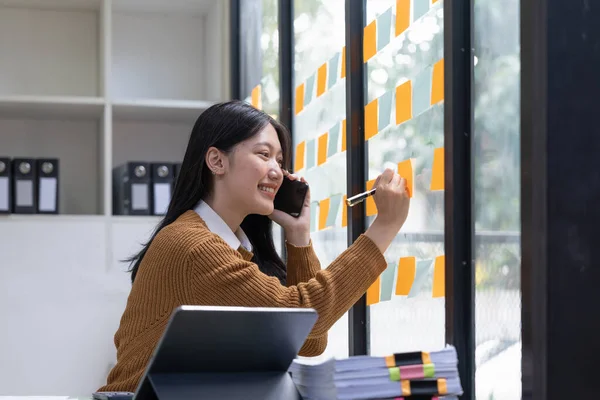 Glimlachende Jonge Aziatische Vrouw Schrijven Plakkerige Notities Venster Creatief Kantoor — Stockfoto