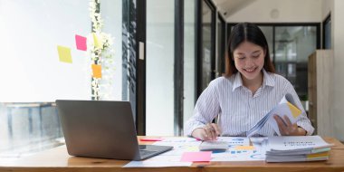 Çekici Asyalı muhasebeci ya da hesap makinesi ve evrak işleriyle uğraşan denetçi.