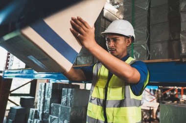 Asyalı erkek depo çalışanı fabrika ürünlerini ve nakliyesini müşteriye yönetir.