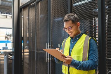 Mutlu Asyalı erkek mühendis fabrika sektöründe çalışmanın keyfini çıkarıyor..