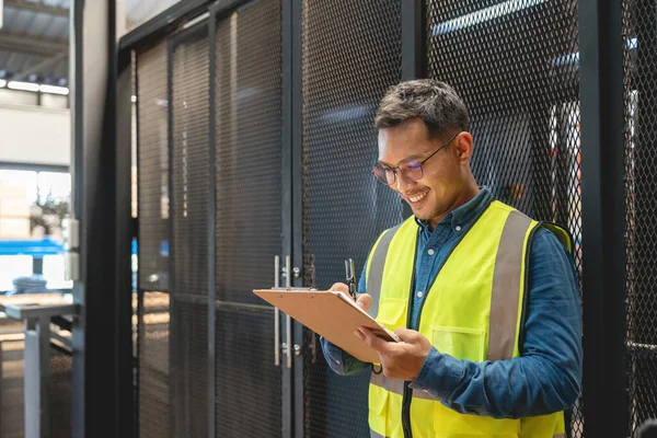 Mutlu Asyalı erkek mühendis fabrika sektöründe çalışmanın keyfini çıkarıyor..