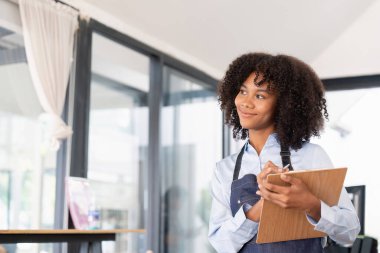 Önlük giymiş gülümseyen Afro-Amerikan bir garsonun portresi. Müşteri siparişini almaya hazır..