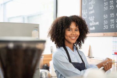 Önlük giymiş gülümseyen Afro-Amerikan bir garsonun portresi. Müşteri siparişini almaya hazır..