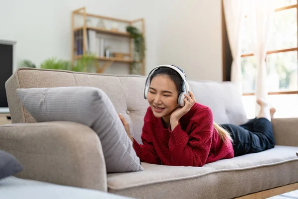 Unbekümmerte Asiatin Die Musik Hört Kopfhörer Benutzt Auf Dem Sofa — Stockfoto