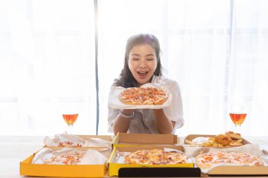 Asyalı portresi Noel 'i şampanyayla ve evde pizza yiyerek kutluyor. Arkadaşlarla ya da meslektaş konseptiyle tatil partisinin neşesi.