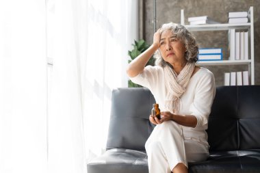 Yaşlı hasta kadın evdeki şişeden hap alıyor..