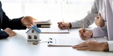 Çiftle bir anlaşma imzalayan bir emlakçı.