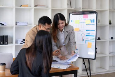 Bir grup iş adamı, pazarlama planının verilerini analiz etmek için toplanıyor.