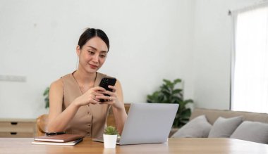 asian woman using mobile phone during checking an email or social media on internet. accounting financial concept.