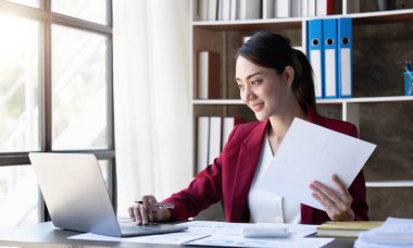 Dizüstü bilgisayara bakan genç bir kadın..
