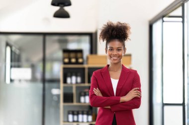 Kameraya gülümseyen başarılı kadın profesyonel. Genç Afrikalı Amerikalı iş kadını kollarını kavuşturdu. Kendine güvenen iş kadını kavramı..