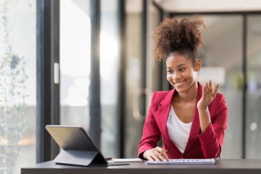 Female office worker working on a laptop in an office.