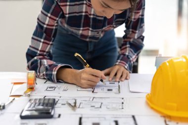 architect working in office with blueprints. Engineer inspect architectural plan, sketching a construction project. Business concept.