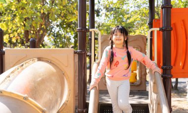 Happy children girl playing and having fun at the playground.