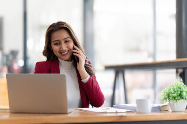 Gülümseyen Asyalı iş kadını. Çizelgeyi ve grafiği analiz ediyor. Piyasadaki değişiklikleri gösteriyor..