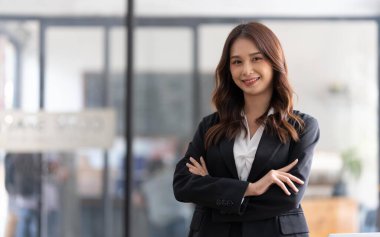 Successful young female entrepreneur, small business owner, female office employee, businesswoman in confident pose with arms crossed.