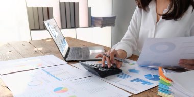 female employee working on a laptop computer in a modern office. Make an account analysis report. real estate investment information financial and tax system concepts.
