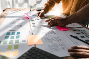 Brainstorm team of creative Web Graphic Designer planning, Group of asia mobile phone app developer team meeting for share ideas about screen prototype layout for smartphone, ui, ux startup small