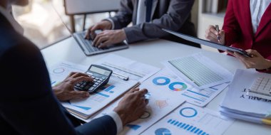 Team of business investment consultant analyzing company annual financial report working with documents pie and donut chart, using laptop, Business and Financial concept.