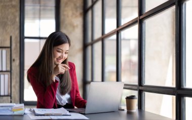 Business Asian woman working on a desk using calculator for calculating Tax finance expense bookkeeper report in office.