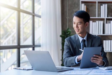 Businessman financing accounting Concept, businessman using tablet and doing finances, calculate about cost to real estate investment and in other, tax system.