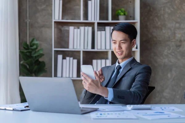 Busy businessman accountant Asian male making look call phone in office working, Startup, report, tax, accounting, statistics, and analytic research concept.