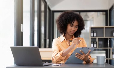Asian Business woman doing math finance on an office desk, tax, report, accounting, statistics, and analytical research concept.