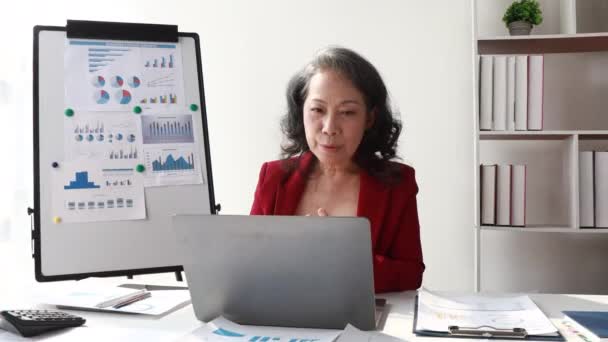 オフィスでコンピュータビデオ通話アプリケーションコンサルティングクライアントが話しているアジアの高級ビジネス女性は 同僚と遠隔作業仮想イベントを通信遠く離れたビジネス女性 — ストック動画