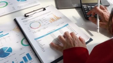 Close-up of senior auditors hand counting expenses of company employees using calculator