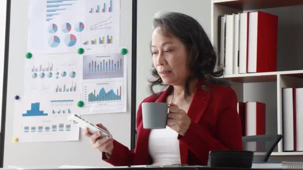 Senior Asian Woman Using Mobile Phone Her Office — Stockvideo