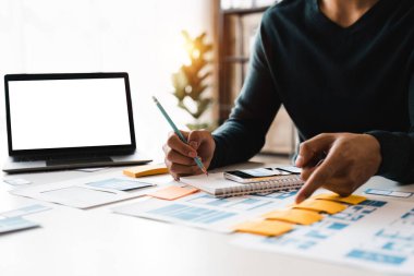 Web sitesi tasarımcısı, Yaratıcı Planlama Telefon Uygulaması Geliştirme şablonu yerleşim şeması kablo şeması tasarımı, Kullanıcı deneyimi konsepti, Ofiste akıllı telefon uygulaması üzerinde çalışan Asyalı genç adam UX tasarımcısı