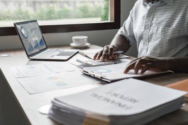 Mutlu siyahi adam bütçe planlama, harcamaları hesaplama ve evde not alma..