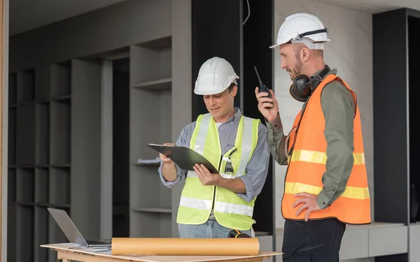 stock image Engineer team discussing meeting on plan at construction site.