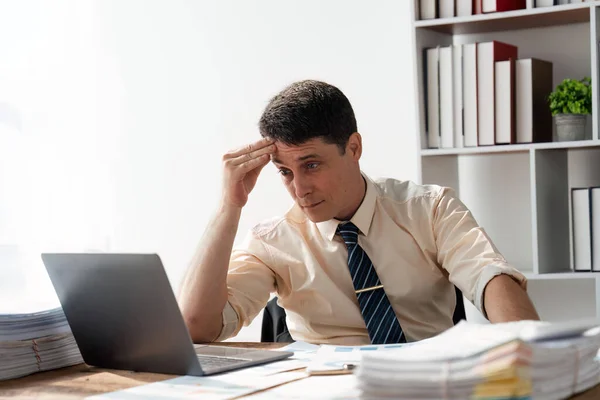 Serious businessman thinking hard of problem solution working in office with computers documents, thoughtful businessman focused on stock trading data analysis analyzing forecasting financial rates.