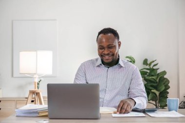 Odaklanmış Afrikalı işadamı dizüstü bilgisayarına bakarak araştırma yapıyor. ticari finansal analist kavramı.
