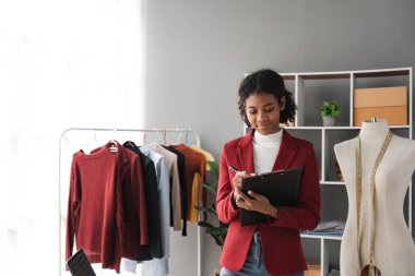 Kadın stilisti Başarılı Moda Şirketi. Gülümseyen Siyah Tasarımcı 'nın portresi moda stüdyosunda duruyor ve çalışıyor. Moda tasarımcısının portresi..