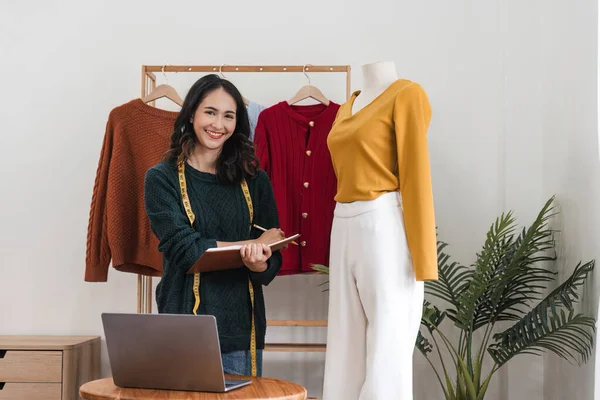 Female stylist Successful Fashion Business. Portrait of Smiling Asian Designer stylish standing and working at fashion studio. Portrait of fashion designer in office.