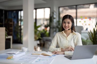 İş yerinde gülümseyen kadın müşteri destek telefonu operatörünün portresi. Çağrı merkezinde çalışan gülümseyen güzel Asyalı kadın..