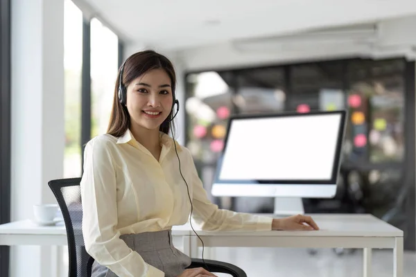 stock image Portrait of happy smiling female customer support phone operator at workplace. Smiling beautiful Asian woman working in call center.