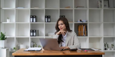 Ofisinde dizüstü bilgisayarla çalışan Asyalı kadın portresi. ticari finansal konsept..