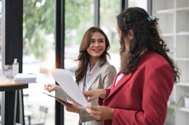 Ofiste çalışırken dizüstü bilgisayarla çalışan iki zeki çoklu etnik iş adamı..