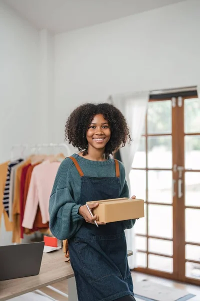 Young attractive woman owner startup business work happy with box at home prepare parcel delivery in sme supply chain, online delivery idea concept.