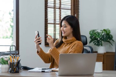 İletişim, bağlantı ve daktilo için telefonu olan bir iş kadını gülümseyerek, mutlu ve rahatlarken. Girişimci, heyecanlı ve dizüstü bilgisayarla evde planlama yapıyor..