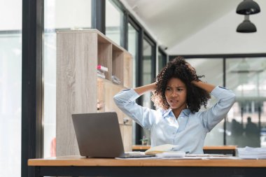 Sıkılmış, baş ağrısı ve stresi olan bir muhasebeci. Siyahi kadın ofiste fazla çalışıyor..