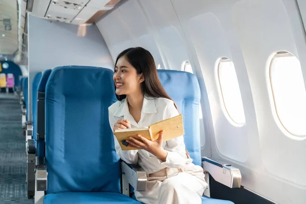 Smiling Asian Woman Taking Notes Information Sitting Airplane Business Traveling — Stock Photo, Image