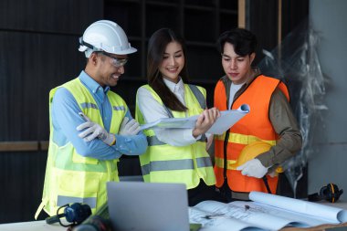 Mühendis ve mimarlardan oluşan bir ekip inşaat alanının planlarını, inşaat konseptini tasarlıyor, tasarlıyor, planlıyor ve ölçüyor..